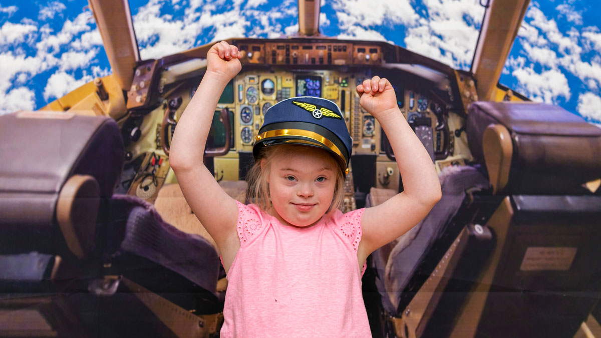 child with down syndrome in airplane simulator